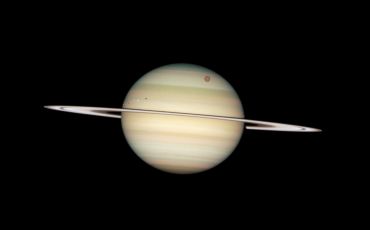 NASA/ESA Hubble Space Telescope captured a photo sequence of four moons of Saturn passing in front of their parent planet. The moons, from far left to right, are the white icy moons Enceladus and Dione (each preceded by their own shadow), the large orange moon Titan, and icy Mimas.